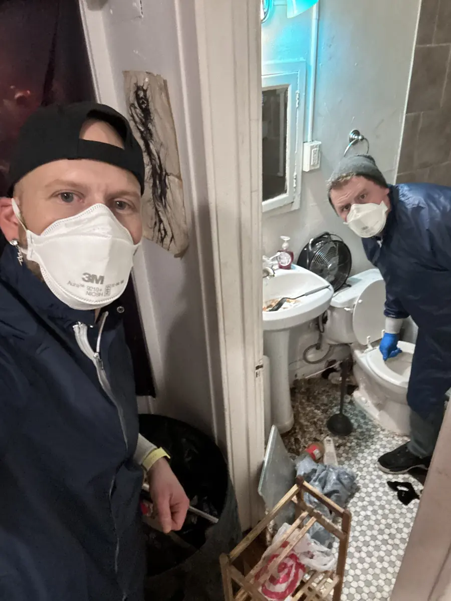 Two BoltZ crew members in masks and gowns starting a heavy-duty bathroom cleanup